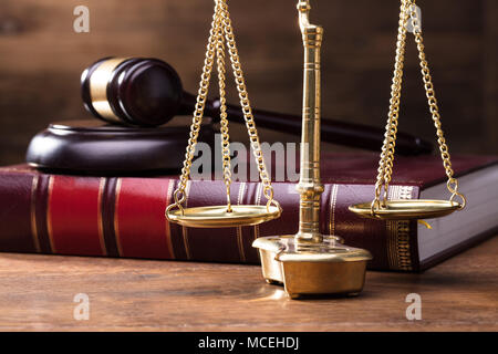 L'échelle d'Or juge en face de Gavel et livre de droit sur la table en bois Banque D'Images