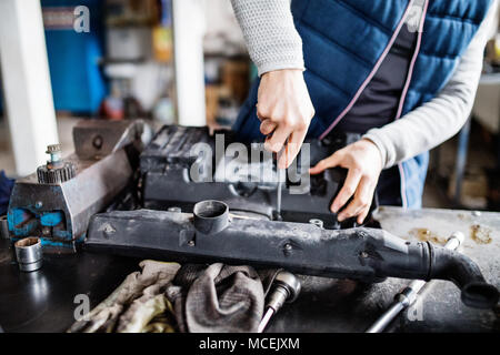 Homme mechanic repairing une voiture dans un garage. Banque D'Images