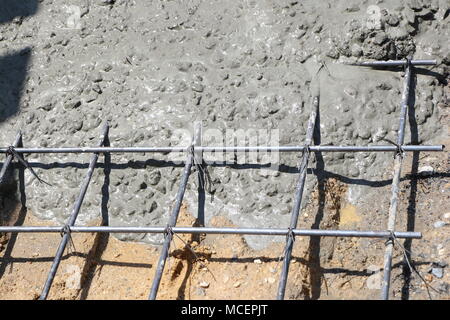 Mouiller le béton est coulé dans un treillis métallique en acier, Banque D'Images