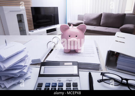 Close-up of Piggybank et documenter avec reçus et Calculatrice sur blanc 24 Banque D'Images