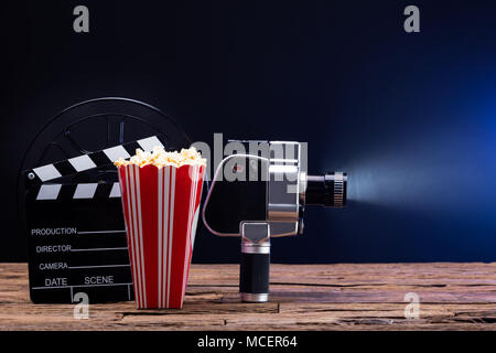 Un appareil photo avec film popcorn et Clapper Board contre fond bleu Banque D'Images