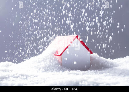 Close-up de la neige qui tombe sur la maison au toit rouge en hiver Banque D'Images