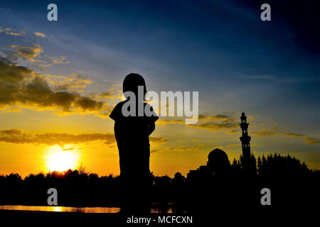 Silhouette d'enfants pendant le coucher du soleil avec l'arrière-plan de la mosquée Banque D'Images