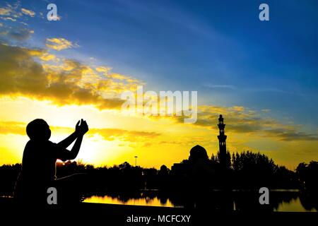 Silhouette d'enfants pendant le coucher du soleil avec l'arrière-plan de la mosquée Banque D'Images