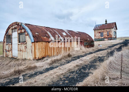 Près de Garður sur la péninsule de Reyjanes, Islande. Vieux bâtiments en tôle ondulée, à une ferme abandonnée sur la côte. Banque D'Images