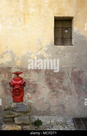 Mur de chambre à Finestret, un village dans le Languedoc-Roussillon, Pyrénées-Orientales, dans le sud de la France. Petite fenêtre avec volets. D'incendie. Banque D'Images