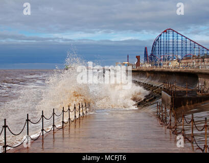 Éclaboussures des vagues contre la défense de la mer, faire une scène pittoresque, avec le grand, Blackpool Pleasure Beach, dans l'arrière-plan Banque D'Images