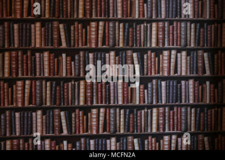 Une chambre avec un mur tapissés de livres à regarder de plus en plus pointues de Portsmouth, Hampshire, Royaume-Uni. Banque D'Images