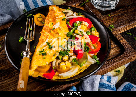 Petit-déjeuner sain, l'alimentation d'oeufs omelette aux légumes farcis, béton sombre contexte copy space Banque D'Images