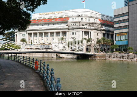 Cavenagh pont suspendu au-dessus de la rivière Singapour et Fullerton hotel en arrière-plan. Banque D'Images