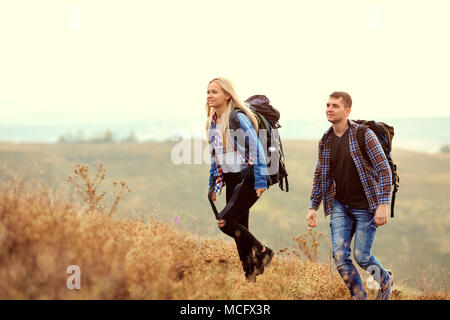 Un jeune couple de touristes avec des sacs à dos sont la marche dans la nature. Banque D'Images