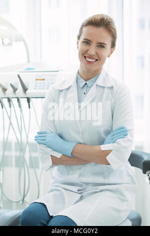 Inspiré dentiste assis avec les bras croisés Banque D'Images