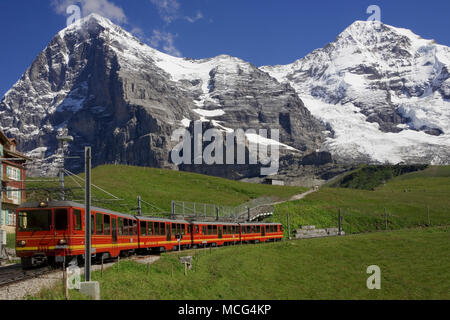 La face nord de l'Eiger et le Mönch, avec l'Eigergletscher tumbling au flanc de la montagne sur la droite et de la Jungfraubahn train dans l'avant-plan Banque D'Images