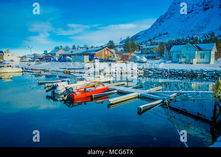 Henningsvær, Norvège - le 04 avril 2018 : vue extérieure de petits bateaux de pêche dans un port de pêche avec une montagne reflet dans l'eau sur les îles Lofoten Banque D'Images