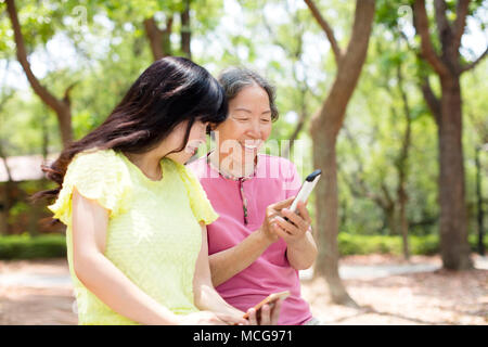 Happy mother and daughter regardant le téléphone intelligent Banque D'Images