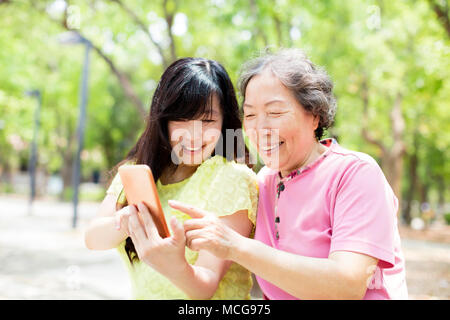 Happy mother and daughter regardant le téléphone intelligent Banque D'Images