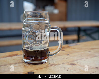 Presque vide German ale beer mug sitting on wooden table Banque D'Images