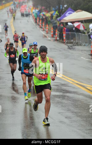 Newton, MA, USA 16 avril 2018 coureurs de marathon s'attaquer au temps orageux et la difficile montée de Heartbreak Hill pour compléter le marathon de Boston/Kirkikis Crédit : James Alamy Live News Banque D'Images