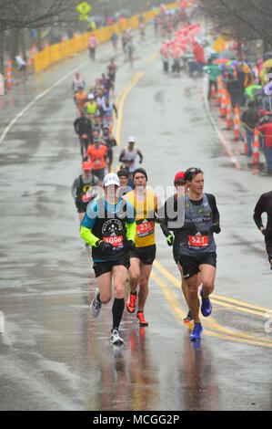 Newton, MA, USA 16 avril 2018 coureurs de marathon s'attaquer au temps orageux et la difficile montée de Heartbreak Hill pour compléter le marathon de Boston/Kirkikis Crédit : James Alamy Live News Banque D'Images