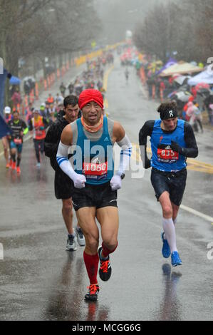 Newton, MA, USA 16 avril 2018 coureurs de marathon s'attaquer au temps orageux et la difficile montée de Heartbreak Hill pour compléter le marathon de Boston/Kirkikis Crédit : James Alamy Live News Banque D'Images