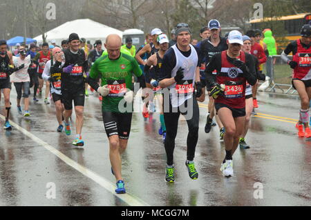 Newton, MA, USA 16 avril 2018 coureurs de marathon s'attaquer au temps orageux et la difficile montée de Heartbreak Hill pour compléter le marathon de Boston/Kirkikis Crédit : James Alamy Live News Banque D'Images