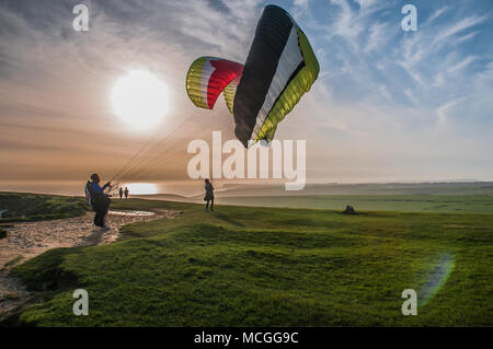 Eastbourne, East Sussex, UK..16 avril 2018..Paragliders sur les South Downs, à l'ouest d'Eastbourne. Un seul pilote a pris l'air dans le vent du sud de l'ouest, ce qui a fait une très longue promenade après avoir atterri sur la plage en dessous. Banque D'Images