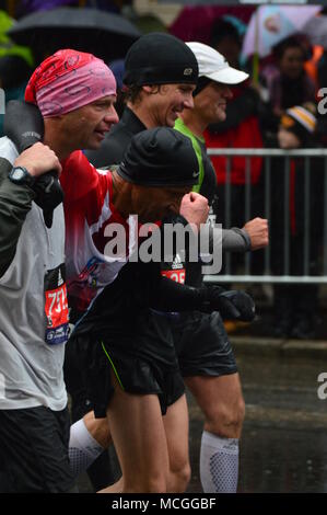 Boston, MA, USA 16 avril 2018 Marathoin porteur aider un coureur blessé comme il apprpoacjhes la ligne d'arrivée du Marathon de Boston/Kirkikis Crédit : James Alamy Live News Banque D'Images