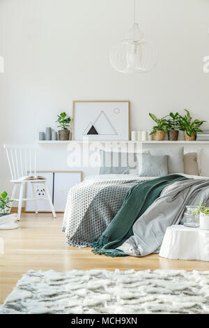 L'intérieur de chambre à coucher avec lit king-size, un tapis, président, ornements et plancher en bois Banque D'Images