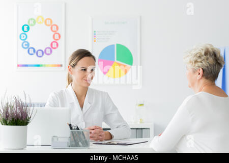 Médecin à un rendez-vous à la recherche heureux avec sa perte de poids du patient cours Banque D'Images