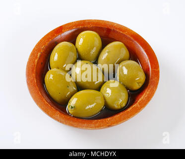 Bol d'olives vertes sur fond blanc Banque D'Images