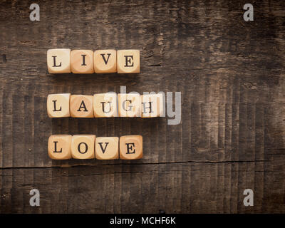 Dés en bois avec les mots live laugh love on a wooden background Banque D'Images