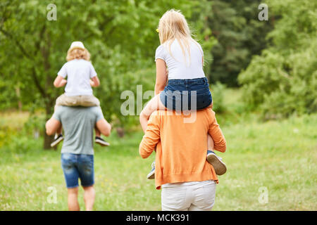 Voyage en famille avec des enfants sur le dos le dos des parents Banque D'Images