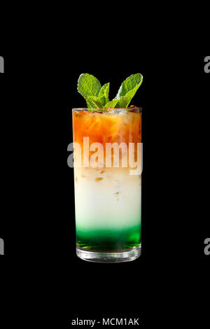 Un multicolores, opaque en trois couches d'un cocktail dans un grand verre de glace pilée et de feuilles de menthe et les grains de café, avec le goût de menthol, café, ca Banque D'Images