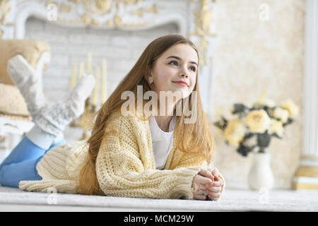 Belle teen girl lying on floor in room Banque D'Images