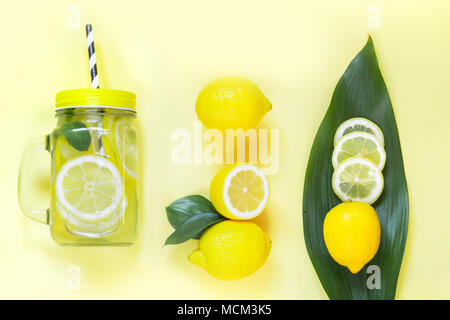 Citron pour la cuisine d'été de composition de la limonade à la menthe et de désintoxication en glace pot Mason sur jaune. Concept Tropical. Vue d'en haut. Mise à plat. Banque D'Images