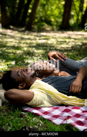 Couple lying dans chaque bras sur un pinic blanket Banque D'Images