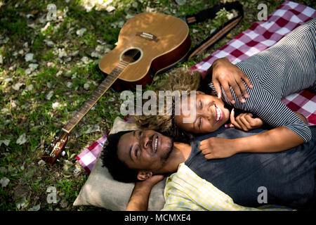 Couple lying dans chaque bras sur un pinic blanket Banque D'Images