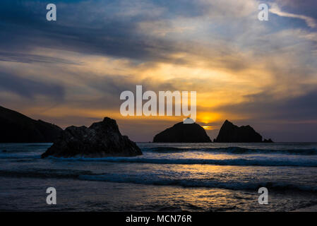 Un spectaculaire coucher de soleil sur les roches des charretiers à Baie de Holywell à Cornwall. Banque D'Images