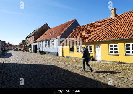 Homme marche le long de la route pavée de la ville d'Ebeltoft Danemark Banque D'Images