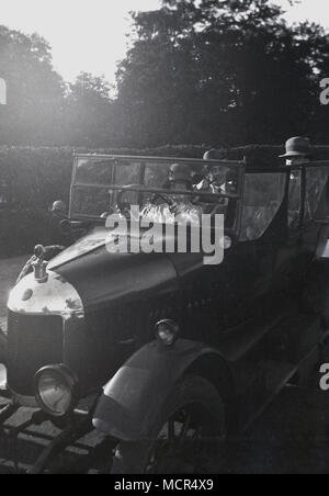 Années 1920, tableau historique du conducteur et des passagers - tous porter un chapeau - assis dans un 'Oxford Bullnose' automobile, un Tourer 4 places faite par la fabricant W.R Morris entre 1919 et 1926 à Oxford, Angleterre, Royaume-Uni. Banque D'Images