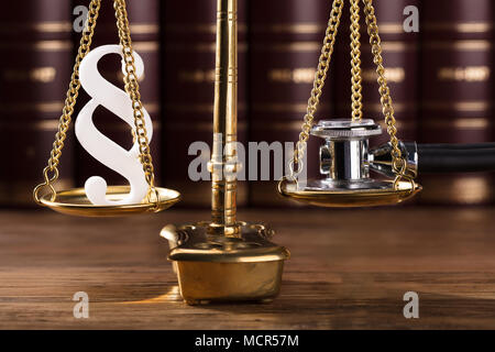 Close-up of White Paragraphe Symbole et stéthoscope sur la justice dans l'échelle d'audience Banque D'Images