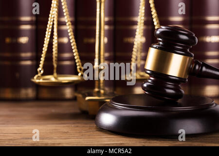 Close-up of Gavel en face de la Justice sur l'échelle d'un bureau en bois Banque D'Images