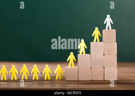 Close-up of White Figure des figures humaines jaune au-dessus de blocs de bois in Classroom Banque D'Images