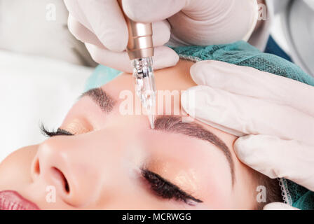 Ce faisant mains esthéticienne tatouage sourcil sur Woman Face.Front Permanent Makeup In Salon de beauté. Libre de faire le sourcil Tattooing pour femme Banque D'Images