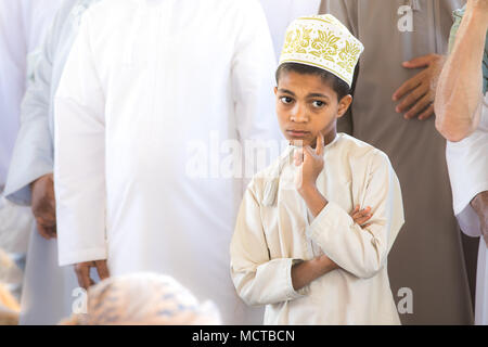 Nizwa, Oman - Mar 23, 2018 : beau jeune garçon omanais de façon réfléchie de poser dans les vêtements traditionnels blanc local. Banque D'Images