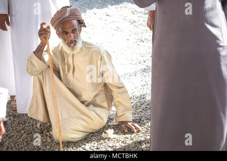 Nizwa, Oman - Mar 23, 2018 : Portrait d'un vieil homme omanais assister à une vente aux enchères le chèvre une chèvre tôt vendredi matin, marché. Banque D'Images