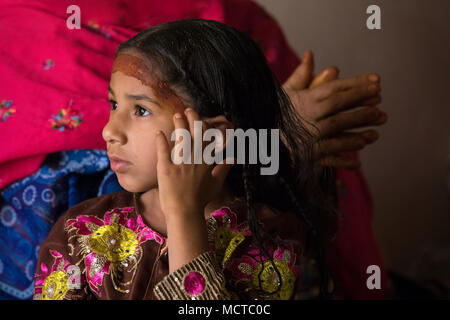 Nizwa, Oman - Mar 23, 2018 : Jeune fille avec des vêtements traditionnels omanais et compléter les lois et en poussant ses cheveux de son visage wit Banque D'Images