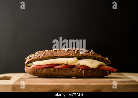 Sandwich de la lumière avec du fromage et de la tomate sur une surface en bois. Banque D'Images