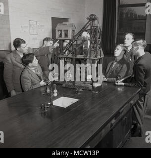 Années 1950, historiques, l'exploitation minière les élèves dans une classe du collège d'être montré un modèle de valorisation de travail par un enseignant, Angleterre, Royaume-Uni. dans la Grande-Bretagne d'après-guerre, l'exploitation minière est une industrie importante avec plus de 500 fosses en existence et le gouvernement de l'époque activement encouragé les jeunes d'apprendre des compétences d'exploitation minière et d'entrer dans l'industrie. Banque D'Images