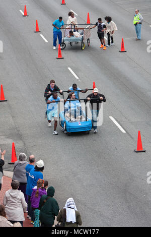 D'un grand angle de vue deux équipes poussant vers le bas la rue ville lits dans la course annuelle de Lawrenceville Bed, le 29 mars 2014 à Lawrenceville, GA. Banque D'Images